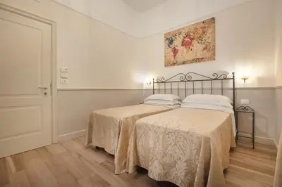 a bedroom with two beds and a painting on the wall at Hotel Flavia in Rome