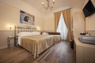 a bedroom with a bed and a chandelier at Hotel Flavia in Rome