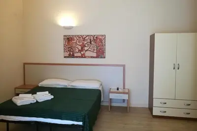 a bedroom with a green bed and a white cabinet at Palma Residences In Rome in Rome