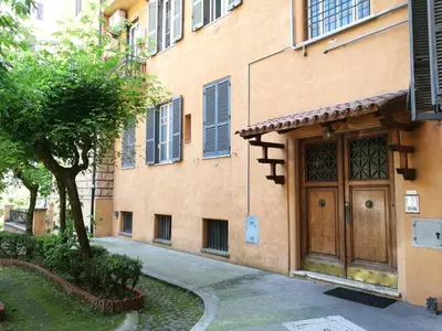 a building with a wooden door next to a tree at Palma Residences In Rome in Rome