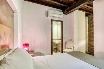 a bedroom with a white bed and a chair at Easybnb - Luxury Navona in Rome
