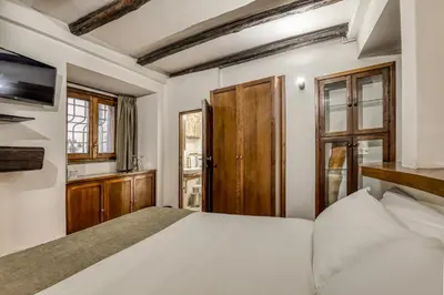 a bedroom with a bed and a tv and windows at Easybnb - Luxury Navona in Rome