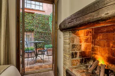 a living room with a fireplace and a patio at Easybnb - Luxury Navona in Rome