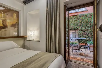 a bedroom with a bed and a balcony with a table at Easybnb - Luxury Navona in Rome