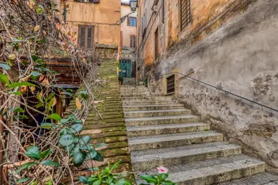 a set of stairs in an alley between two buildings at Easybnb - Luxury Navona in Rome