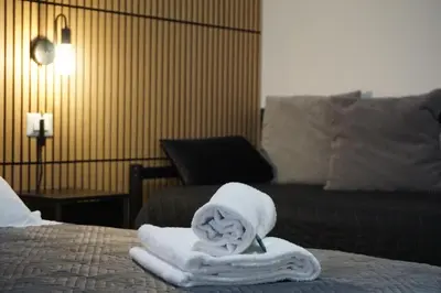 a hotel room with towels on a bed with a couch at VMH Vatican Modern House in Rome