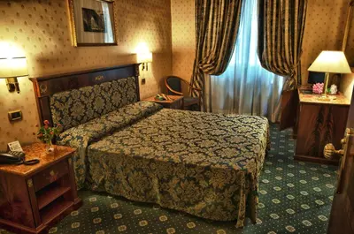 a hotel room with a bed and a table at Hotel Cilicia in Rome