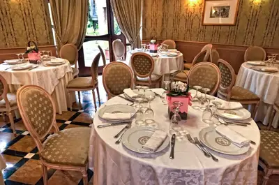 a dining room with tables and chairs with white tablecloths at Hotel Cilicia in Rome