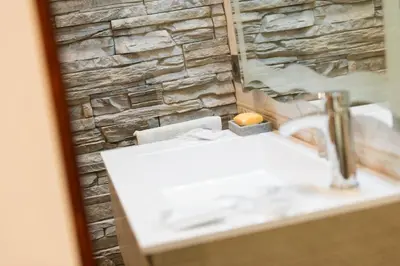 a bathroom with a sink and a stone wall at Lorenz Suites Trastevere Hill in Rome