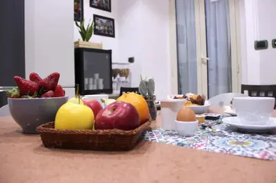 a table with a basket of fruit and eggs on it at Lorenz Suites Trastevere Hill in Rome