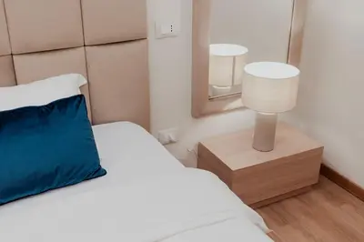 a bedroom with a bed with a blue pillow and a mirror at Cesare ai Cavalieri Suites in Rome