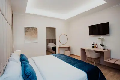a bedroom with a bed and a desk with a television at Cesare ai Cavalieri Suites in Rome