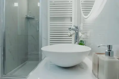 a white bathroom with a sink and a shower at Cesare ai Cavalieri Suites in Rome