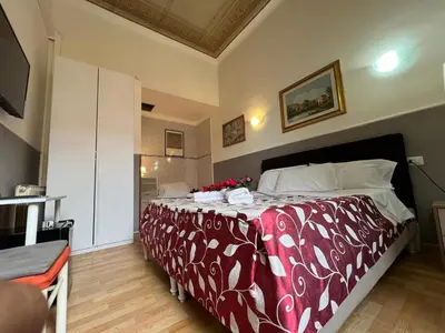 a bedroom with a large bed with a red and white blanket at Affitacamere Radi in Rome