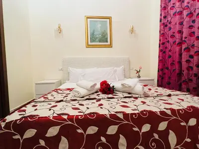 a bedroom with a large bed with a red and white blanket at Affitacamere Radi in Rome