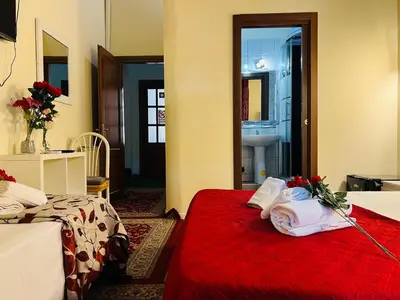 a hotel room with two beds and a red blanket at Affitacamere Radi in Rome