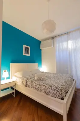 a bedroom with a bed with a blue wall at Borgo Vittorio St. Peter Apartments in Rome