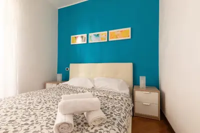 a bedroom with a blue wall and a bed with towels at Borgo Vittorio St. Peter Apartments in Rome