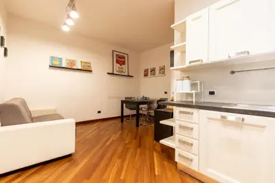 a kitchen with white cabinets and a table at Borgo Vittorio St. Peter Apartments in Rome