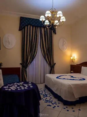 a hotel room with two beds and a chandelier at Caroline Suite in Rome