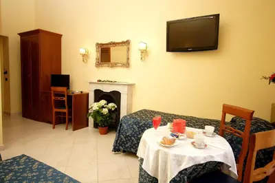 a room with a table and a tv on the wall at Caroline Suite in Rome