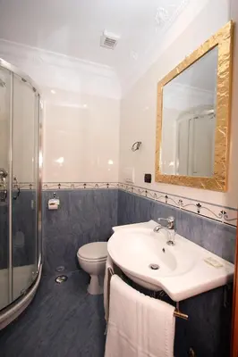 a bathroom with a sink and a toilet and a mirror at Caroline Suite in Rome