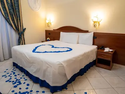 a bedroom with a bed with a blue and white comforter at Caroline Suite in Rome