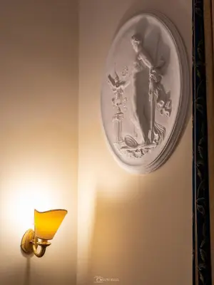 a plate hanging on a wall next to a lamp at Caroline Suite in Rome