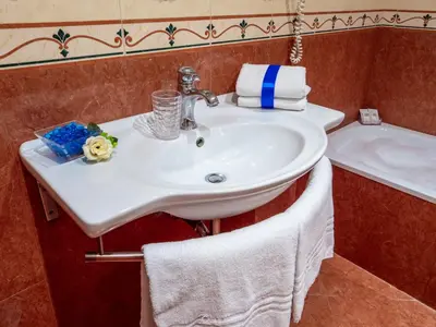 a bathroom with a white sink and a bath tub at Caroline Suite in Rome