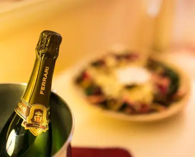 a green bottle of wine in a bucket with a plate of food at Hotel Erdarelli in Rome