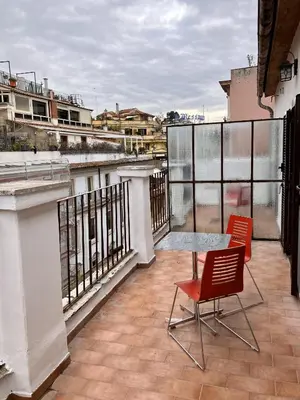 a balcony with two chairs and a table on it at Hotel Erdarelli in Rome
