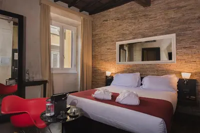 a bedroom with a large bed and a brick wall at Relais 88 in Rome