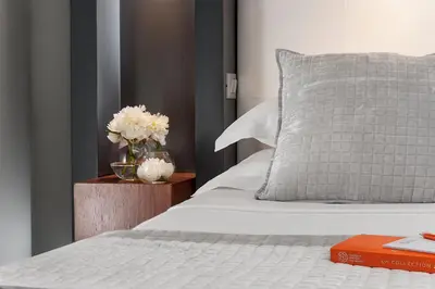 a bed with a vase of flowers on a night stand at Hotel Metropolis in Rome