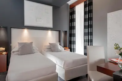 a bedroom with two beds and a table and a desk at Hotel Metropolis in Rome