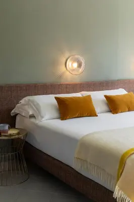 a bedroom with a bed with white sheets and brown pillows at Hotel Marisa in Rome