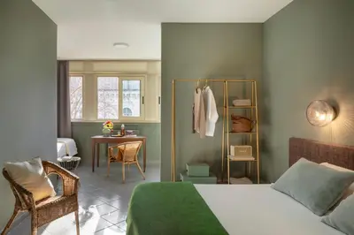 a bedroom with a bed and a chair and a table at Hotel Marisa in Rome