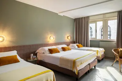 a hotel room with two beds and a chair at Hotel Marisa in Rome