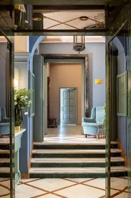 a hallway with blue walls and stairs with a blue couch at Hotel Marisa in Rome