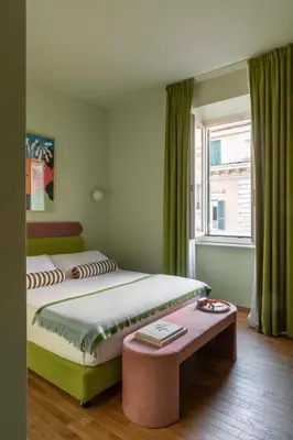 a bedroom with a bed and a table and a window at Hotel Marisa in Rome