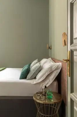 a bed with white sheets and pillows and a table at Hotel Marisa in Rome