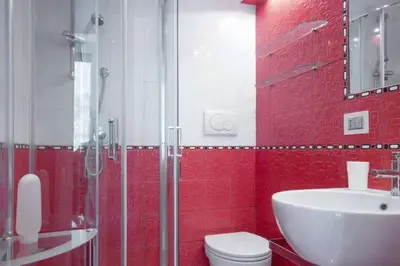 a red bathroom with a toilet and a sink at Trastevere St. Garden House in Rome