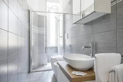 a white bathroom with a sink and a shower at St.Peter Accomodation in Rome