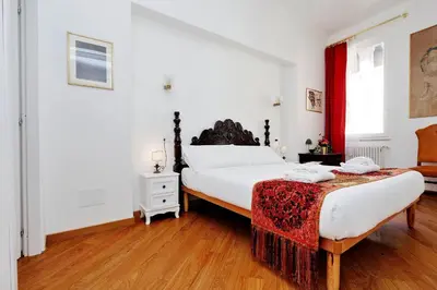a bedroom with a large bed with a red curtain at Sistina in Rome