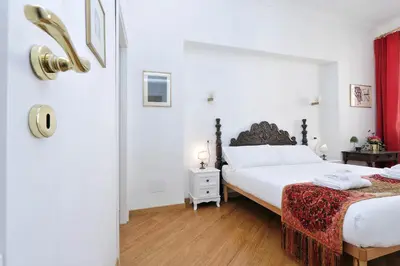 a bedroom with two beds and a red curtain at Sistina in Rome
