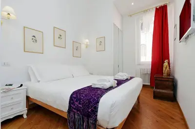 a white bedroom with a bed and a window at Sistina in Rome