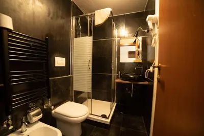 a small bathroom with a toilet and a shower at Ronda St. Angelo Suites in Rome