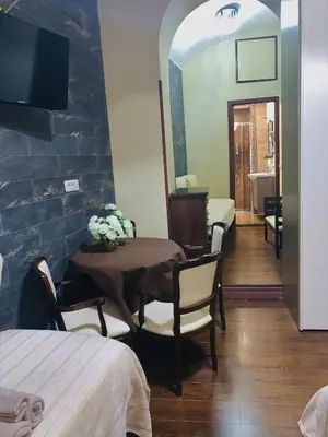 a room with a table and chairs and a mirror at Ronda St. Angelo Suites in Rome