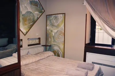 a bedroom with a bed and a painting on the wall at Ronda St. Angelo Suites in Rome