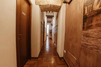 a hallway with a long corridor with wood floors and a ceiling at Ronda St. Angelo Suites in Rome