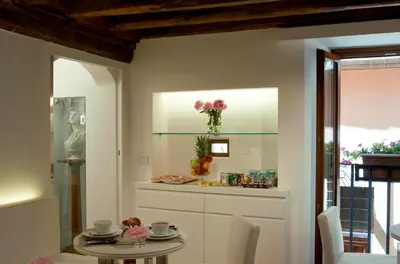 a dining room with a table and a vase of flowers at Gigli D'Oro Suite in Rome
